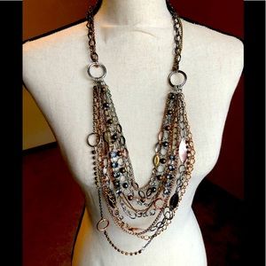 Multi tone necklace with multiple tiered strands.